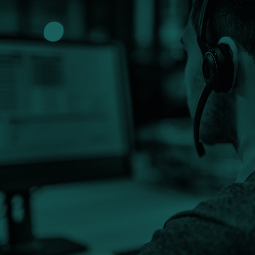 Insurance agent working on a computer with headset in duotone